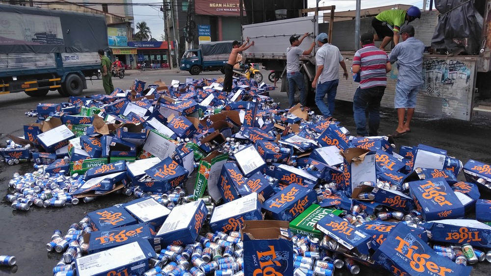 Người dân giúp tài xế gom hàng trăm thùng bia đổ ra đường